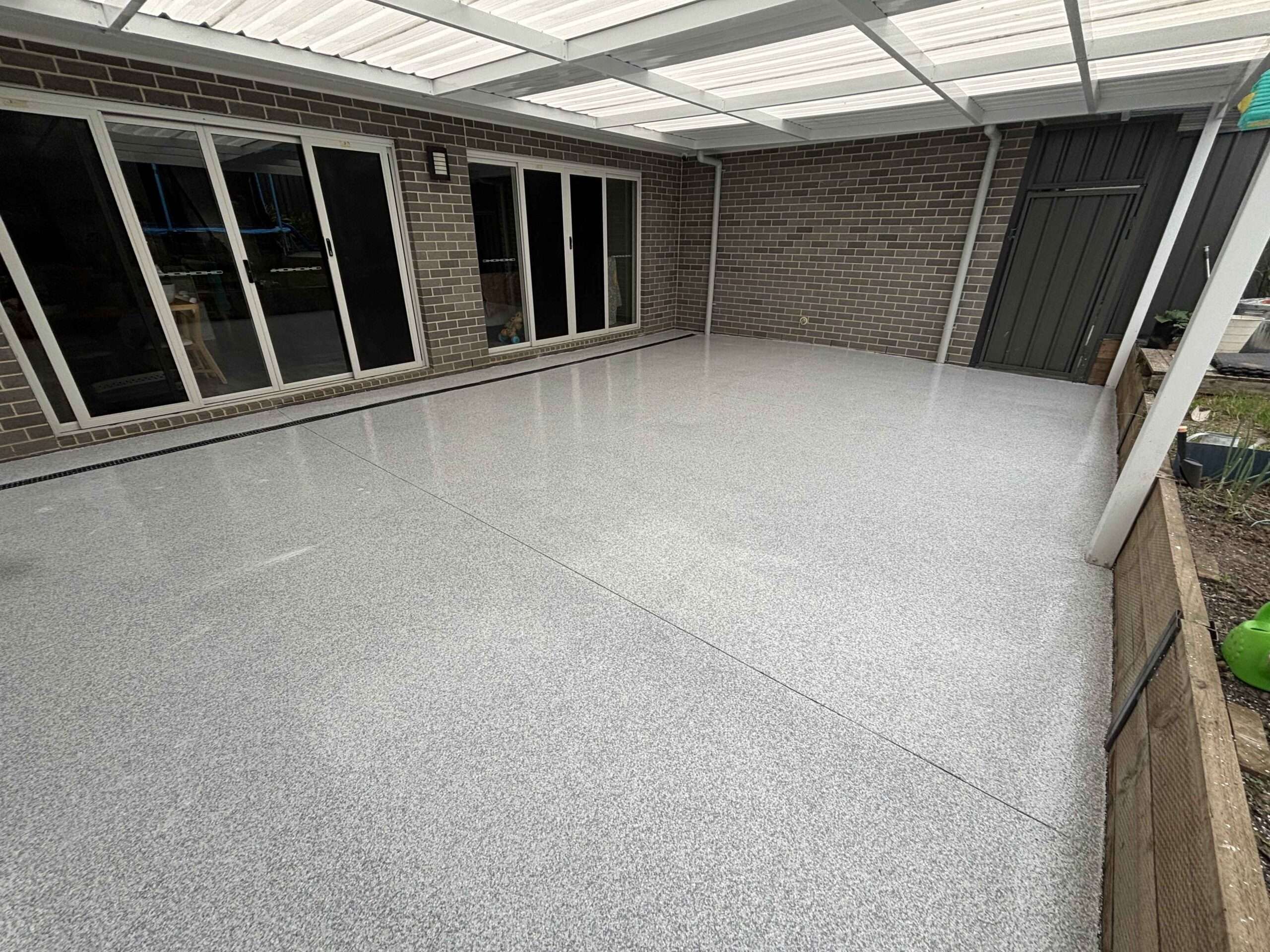 Light grey flake epoxy flooring under covered pergola in Wollongong