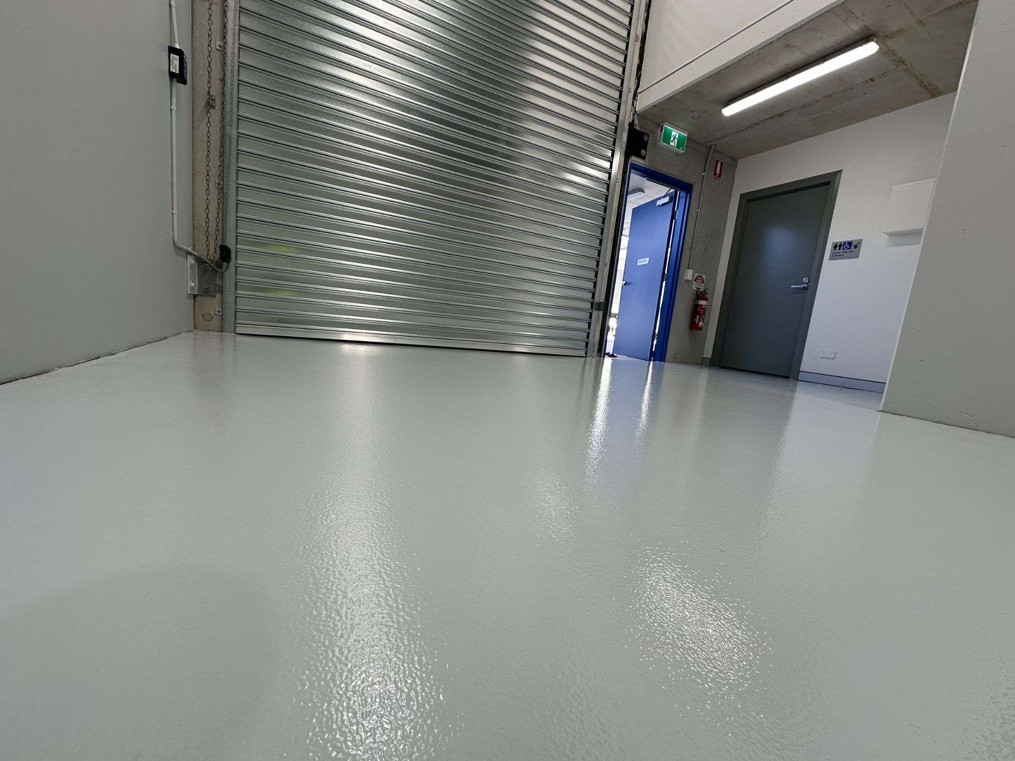 ESD epoxy flooring installed up to a roller door in a Sydney warehouse