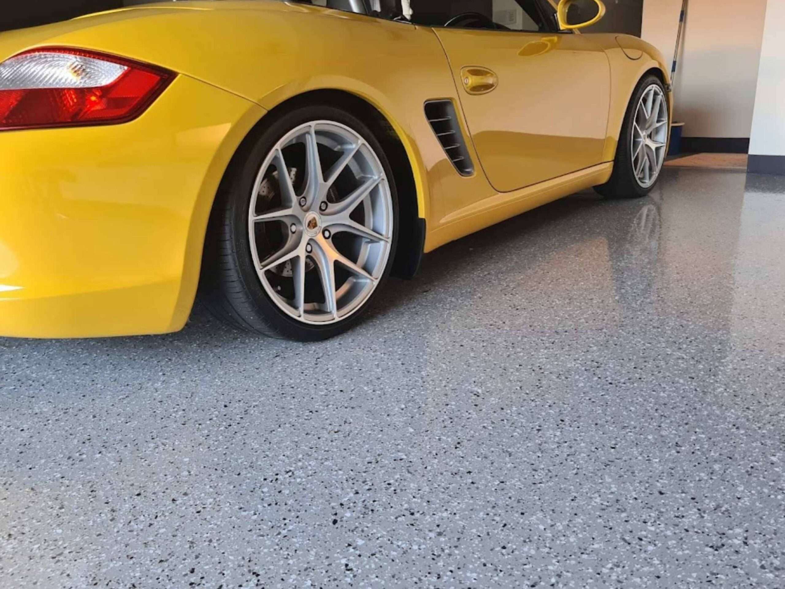 Yellow sports car parked on grey flake garage epoxy flooring in Sydney